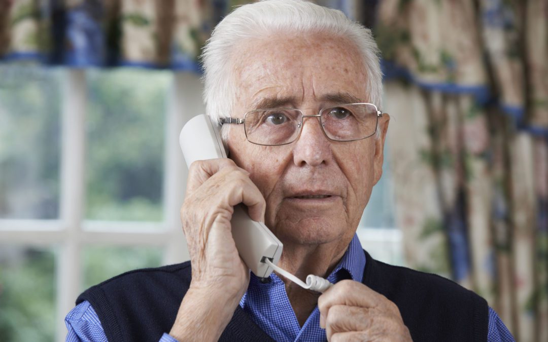 worried senior man answering telephone at home